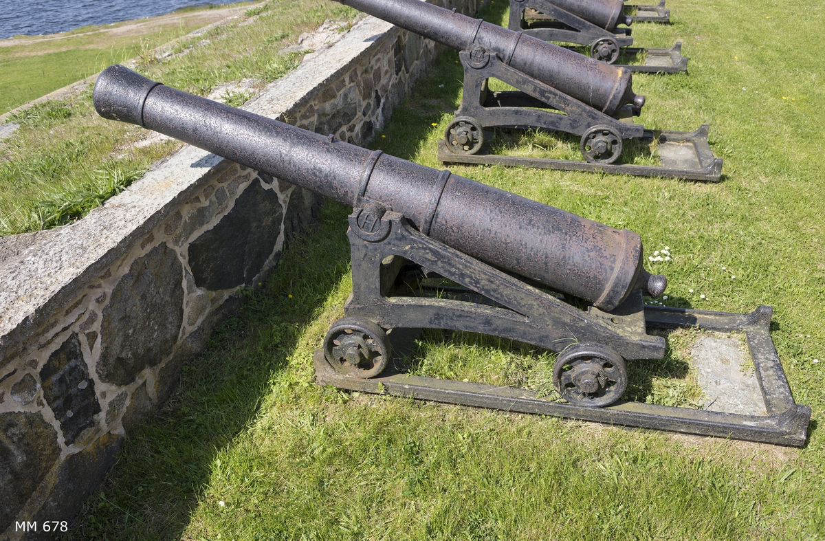 6 pundig slätborrad framladdningskanon M/Ashling, av 310 kulors vikt, med lavett, L = 2050 mm B = 830 mm H = 1000 mm och kursör, av järn. Kanonens gjut. nr 34. Märkt å ena tappen "H" och å den andra "85".