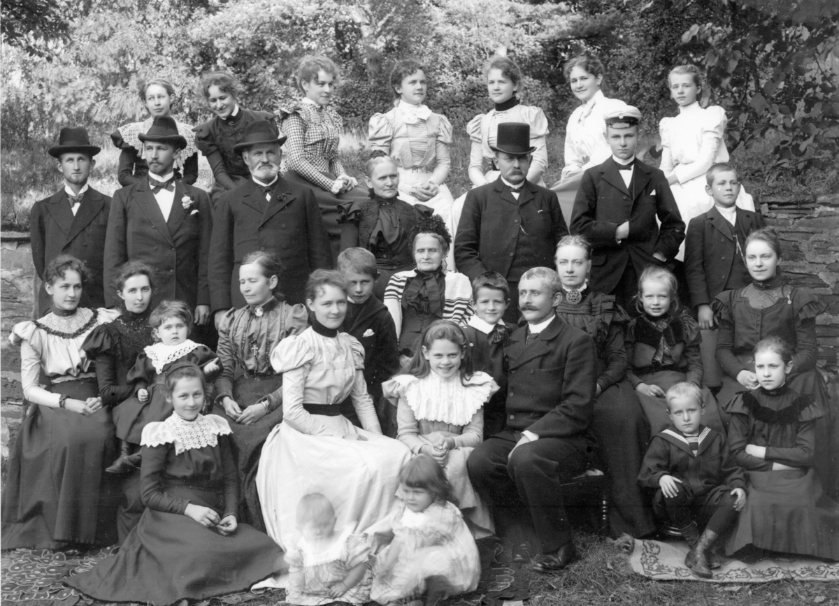 Fotoarkivet etter Gunnar Knudsen. Gruppebilde.
Søsknene Jørgen Chr., Serine og Gunnar Knudsen med ektefeller og barn. I midten sitter søsknenes mor Gurine.