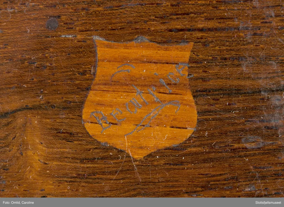 Polert rektangulær eske som inneholder anlegget til spilledåsen.