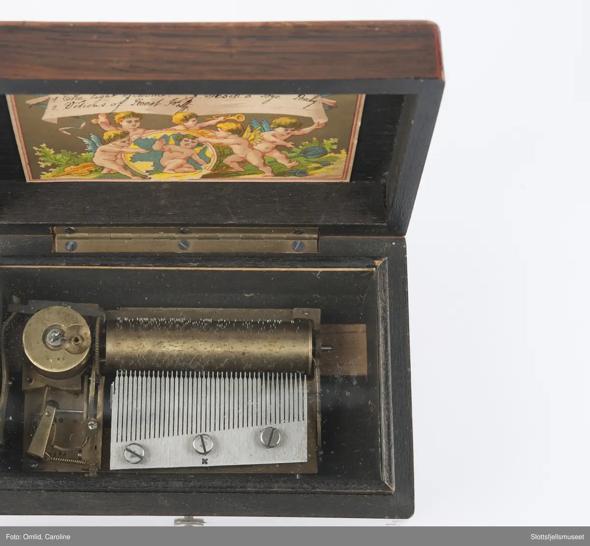 Polert rektangulær eske som inneholder anlegget til spilledåsen.