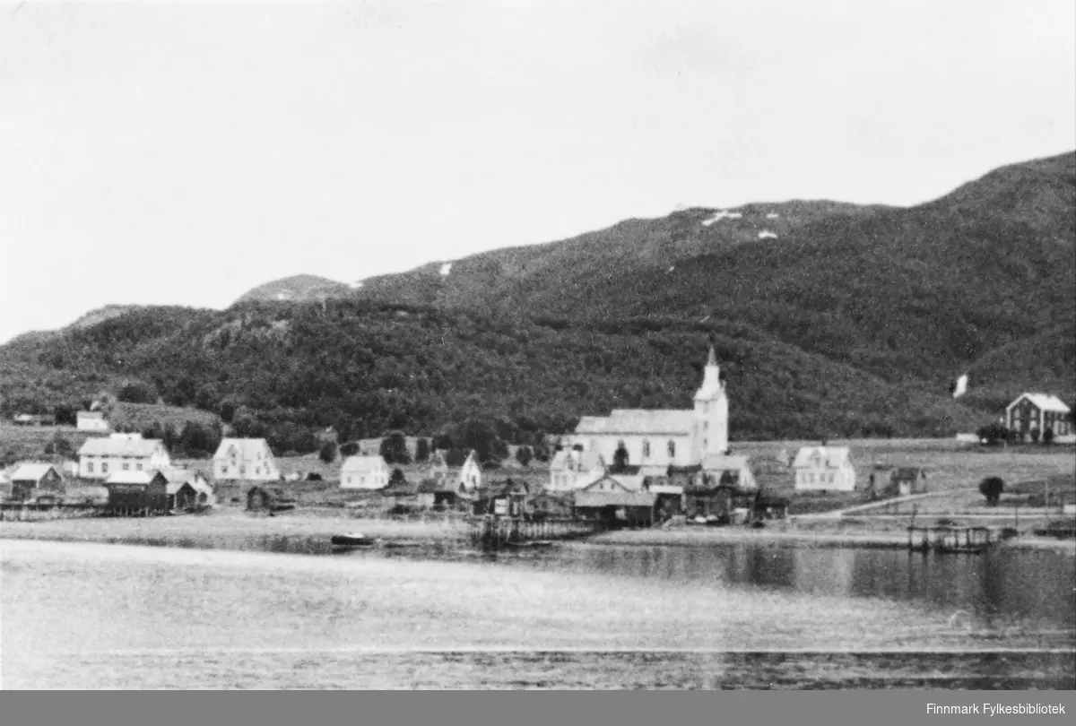 Talvik før krigen, fotografert fra sjøen. Vi ser bygda med kirka. Kommunen ble totalskadet under krigen. Kirka i Talvik og kapellene i Leirbotn og Langfjorden (Sopnes) var det eneste som stod igjen.