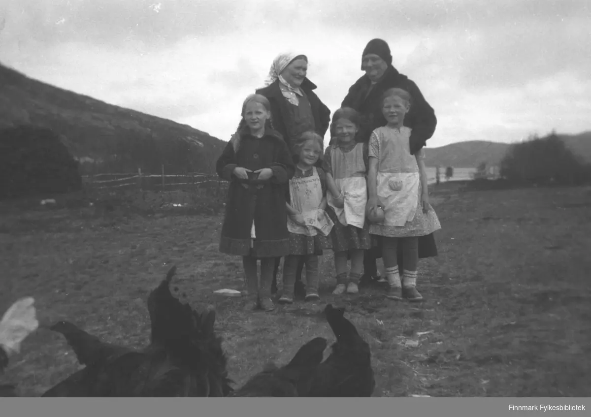 På Mikkelsnes ca. 1932-1935. Jentene fra venstre: Gudrun, Astrid, Ingrid og Kari Mikkola. Bak fra venstre: Kathinka Mikkola, Amanda Olsen Lie. I forgrunnen en flokk høner