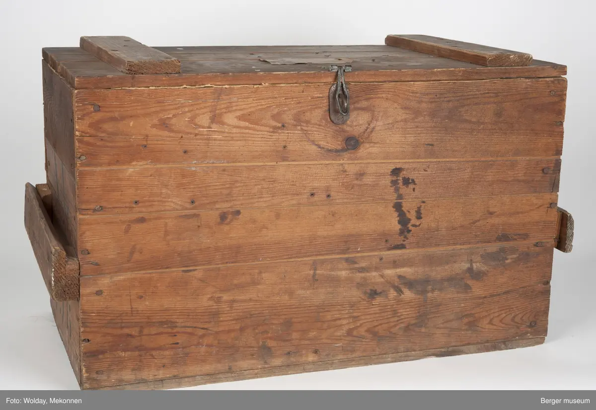 En enkel trekasse spikret sammen av bord i tre bordhøyder. Bordene kan være delvis gjenbruk, basert på eldre stempeltrykk på dem. Kassen har et enkelt håndtak på hver kortende, spikret på et tverrbord satt på to avstandsklosser på kantene. Lokket er hengslet på toppen med to vippehenglser i bakkant, og kan låses ved et hengsel for hengelås påsatt i front.
Kisten er foret innvendig med papp festet med pappstifter.