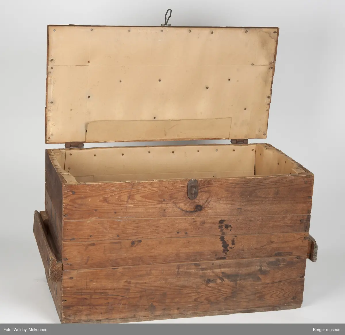 En enkel trekasse spikret sammen av bord i tre bordhøyder. Bordene kan være delvis gjenbruk, basert på eldre stempeltrykk på dem. Kassen har et enkelt håndtak på hver kortende, spikret på et tverrbord satt på to avstandsklosser på kantene. Lokket er hengslet på toppen med to vippehenglser i bakkant, og kan låses ved et hengsel for hengelås påsatt i front.
Kisten er foret innvendig med papp festet med pappstifter.