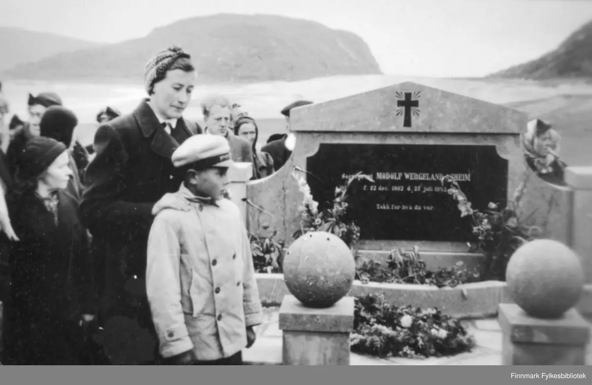 Avduking av minnesmerket over sogneprest Modolf Wergeland Asheim. Sogneprest Asheim døde 23. juli 1942 på Talvik tuberkulosesanatorium. Begravet på Loppa kirkegård. Gravminnet ble reist etter krigen, ca. 1946-47 for midler som meningheten samlet inn. Sogneprestens kone, Ingeborg Asheim og sønnen John-Birger Asheim var til stede under minnestunden, men de hadde da flyttet til Oslo. Sognepresten virket 15 år på øya Loppa og er en av få prester som døde i Finnmark og som valgte å bli gravlagt i Finnmark.|Sogneprest Asheim hadde en spesiell plass i Loppafolkets hjerter, noe det vakre minnesmerket også vitner om.
