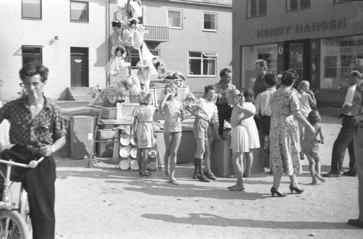 Bilde fra en tombola på Vadsø Torg. Ungutten på sykkel, til venstre i bildet er Anders Trane ca. 20 år gammel (født 1940). Henry Hansen er visst også med i bildet. Bildet er tatt rundt 1960 av Leif Hauge.