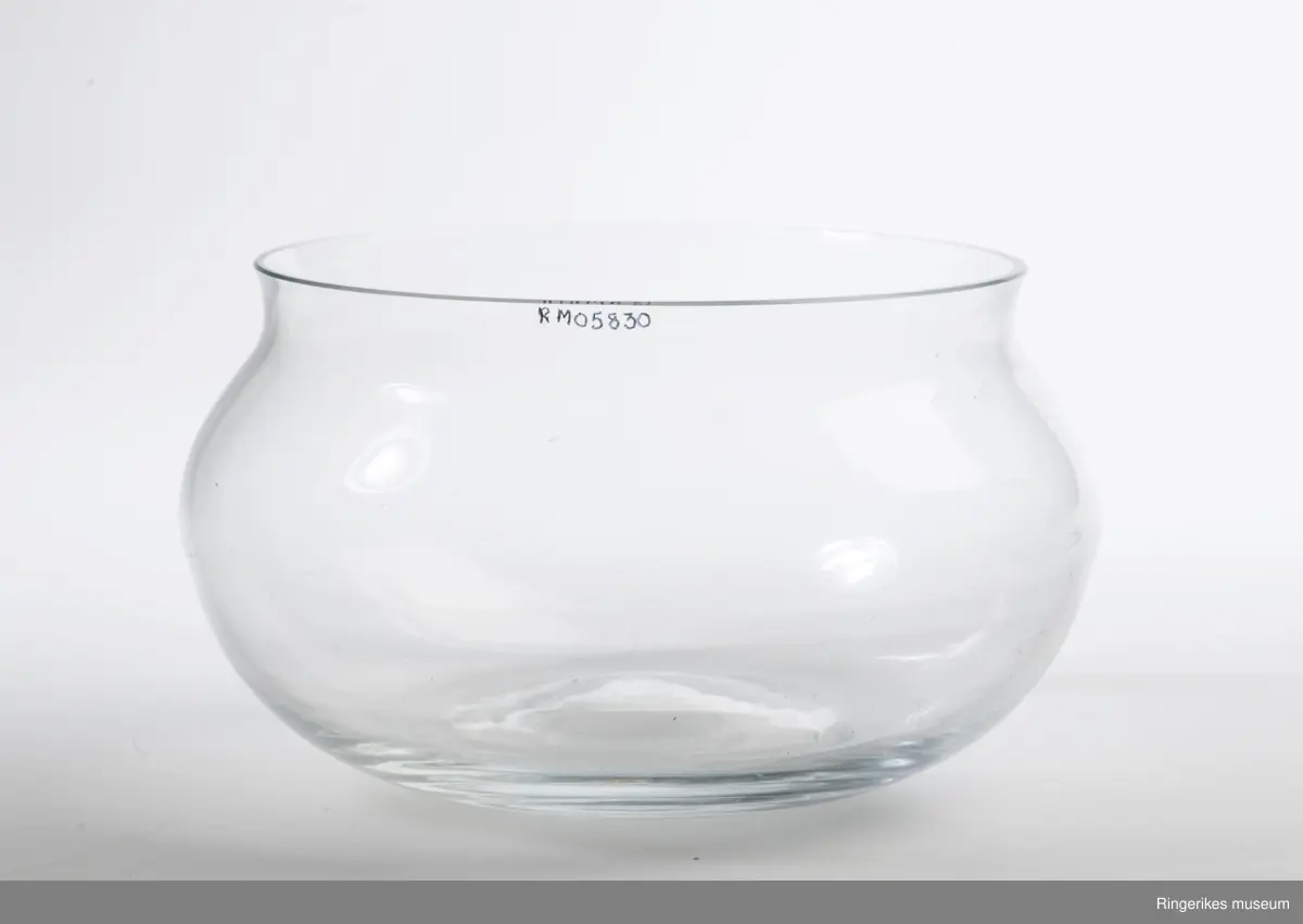 Vid og åpen sikulær bolle, avsluttes med kort innsnevret hals. Lett konkav i bunnen som følge av glassblåsingen.