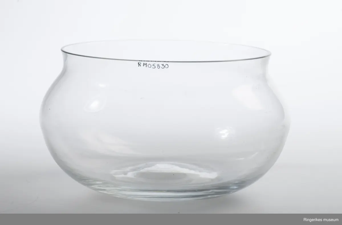 Vid og åpen sikulær bolle, avsluttes med kort innsnevret hals. Lett konkav i bunnen som følge av glassblåsingen.