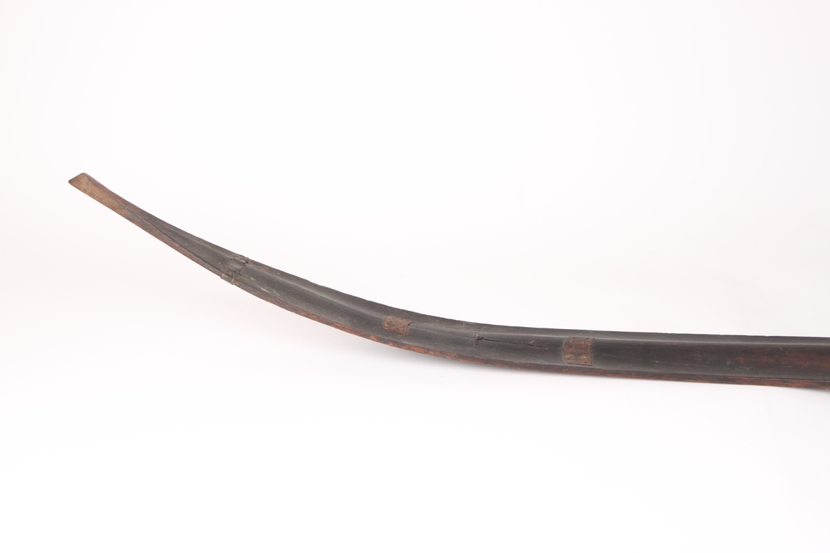 Et par ski, trolig i ask. Framskien er avsmalnende og bakskien er jevnbred. Skiens forende har en profilert tupp, type nese. Bakskien ender i en oppbøyd spiss. Skiens overside har en møneformet rygg med hulkil, og en dyp midtrand under. 
Bindingen er i skinn, festet med tau. Fotstegplaten i bjørkenever er festet med metallstifter.