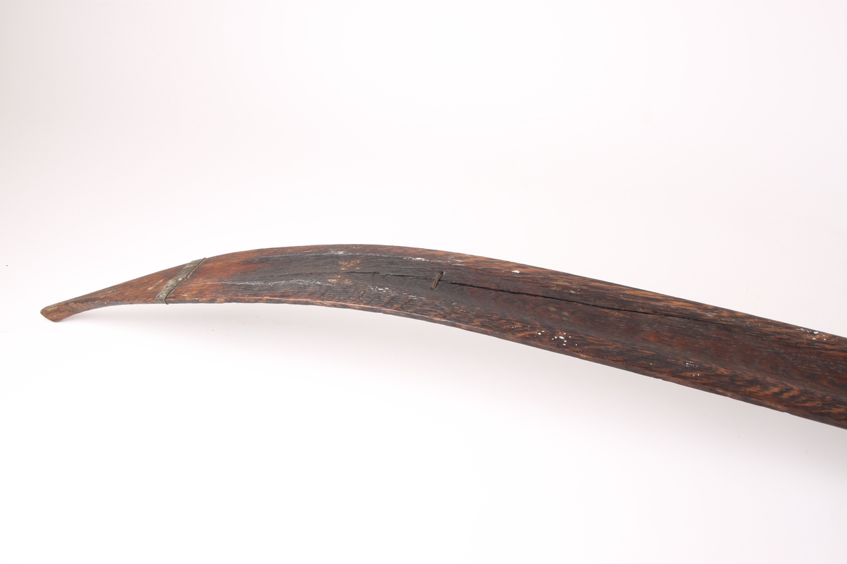 Et par ski, trolig i ask. Framskien er avsmalnende og bakskien er jevnbred. Skiens forende har en profilert tupp, type nese. Bakskien ender i en oppbøyd spiss. Skiens overside har en møneformet rygg med hulkil, og en dyp midtrand under. 
Bindingen er i skinn, festet med tau. Fotstegplaten i bjørkenever er festet med metallstifter.