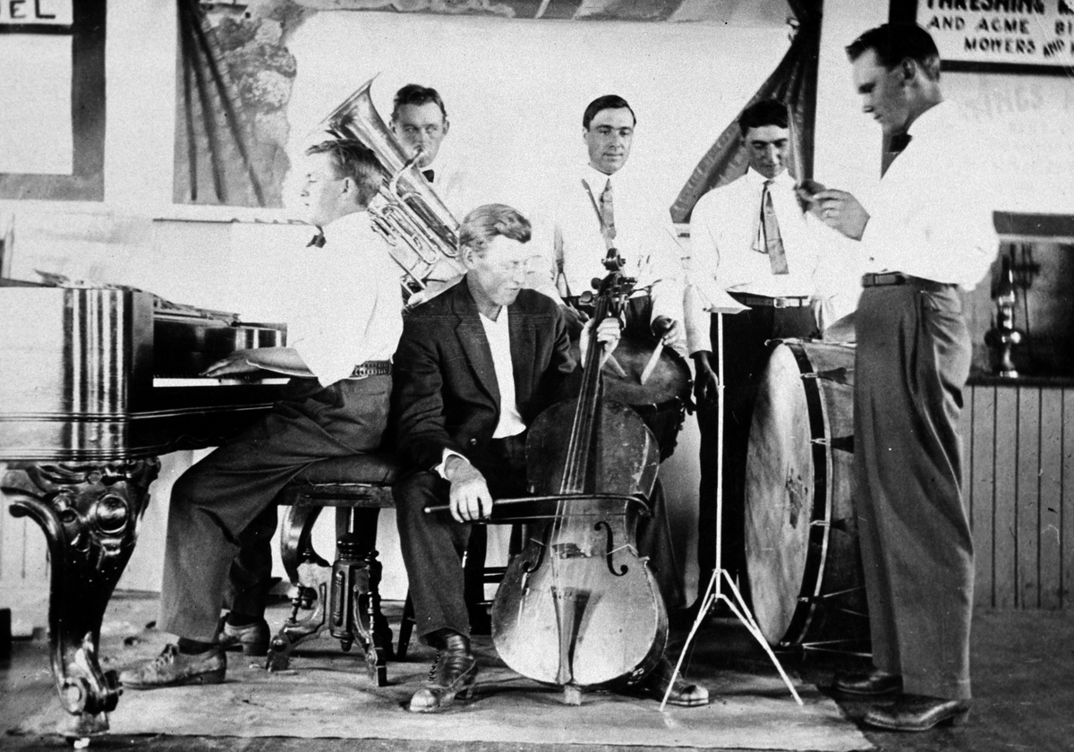 Amerikabilder, Per Mæhlum, Vallset.
Gruppebilde av et orkester, seks personer, Jens Mæhlum ved pianoet, resten er ukjente. Hastings, Nord-Dakota.
 Instrumenter, band, orkester.