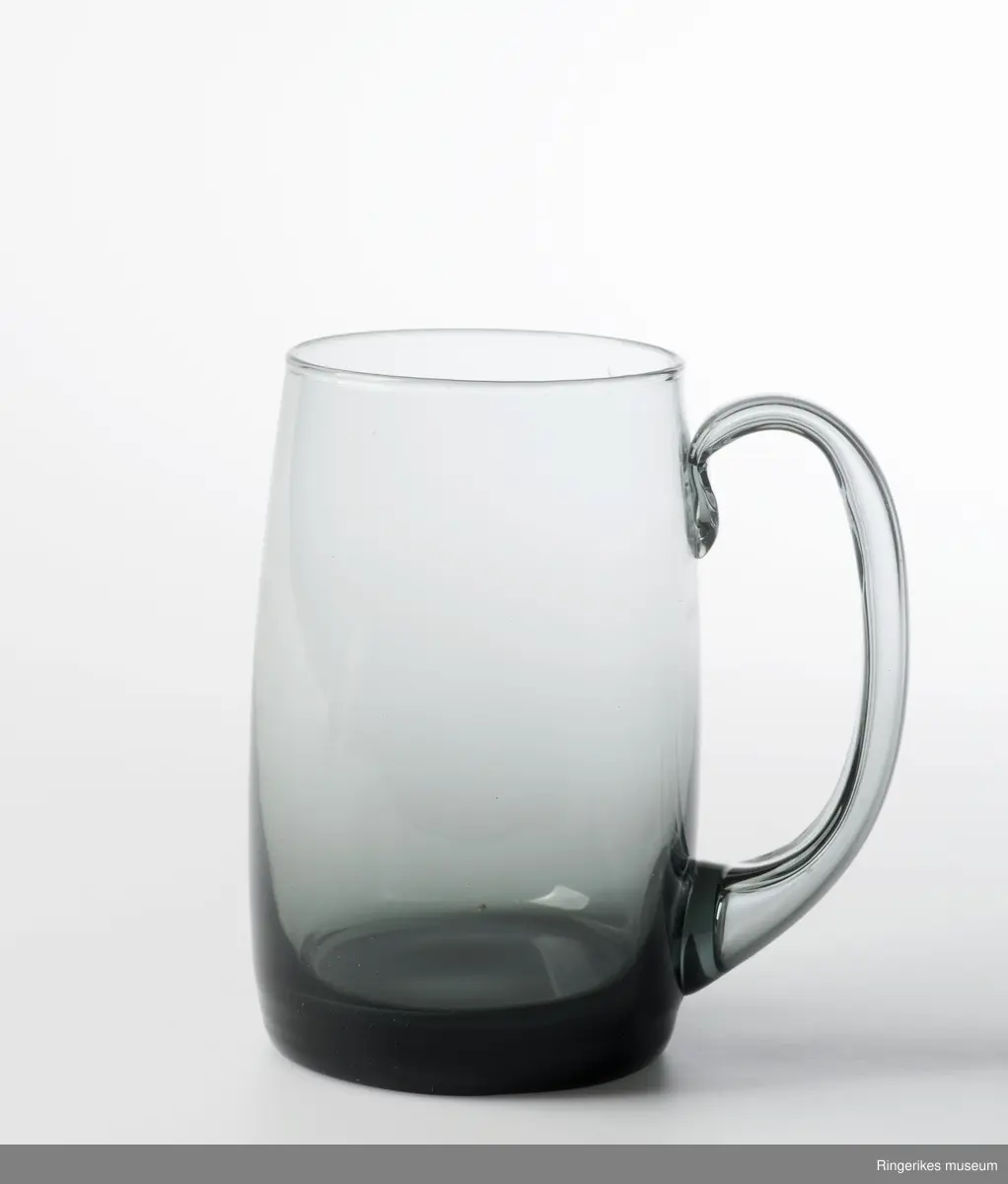 Fire like glass i form og størrelse, To farger. sylinderformet med konvekst midtparti, Buet - C-formet  hank. Designglass fraHadeland glassverk i egen serie og svært populært på 1970-tallet. Mest brukt til øl.