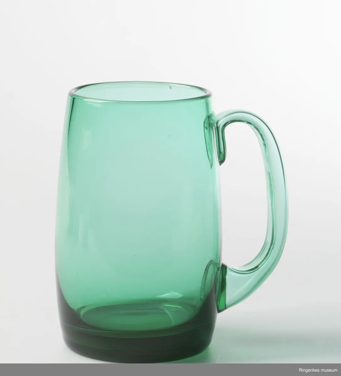 Fire like glass i form og størrelse, To farger. sylinderformet med konvekst midtparti, Buet - C-formet  hank. Designglass fraHadeland glassverk i egen serie og svært populært på 1970-tallet. Mest brukt til øl.