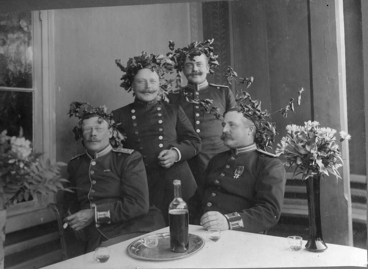 Män i uniform med lövkrans på huvudet.