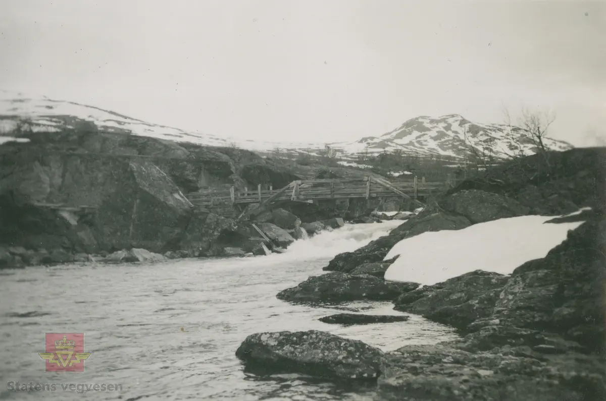 Album fra 1929-1943.  Landskap i Sjodalen. Kan være bilde av den gamle trebrua/gangbrua over Sjoa ved  Maurvangen. 

Bildet er tatt i Sjoa mellom Gjende og Øvre Sjodalsvatn. Rett ved dagens Maurvangen Camping. Fjellet i bakgrunnen er Brurskarsknappen. (Opplysninger fra Dag Erlend Lohne Mohn).