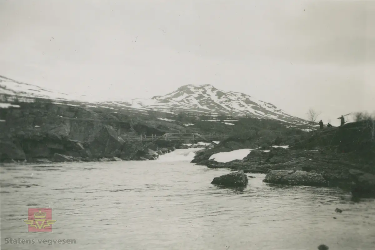 Album fra 1929-1943. Bilde fra Sjodalen. Kan være bilde av den gamle trebrua/gangbrua  over Sjoa ved  Maurvangen. 

Bildet er tatt i Sjoa mellom Gjende og Øvre Sjodalsvatn. Rett ved dagens Maurvangen Camping. Fjellet i bakgrunnen er Brurskarsknappen. 
(Opplysninger fra Dag Erlend Lohne Mohn).