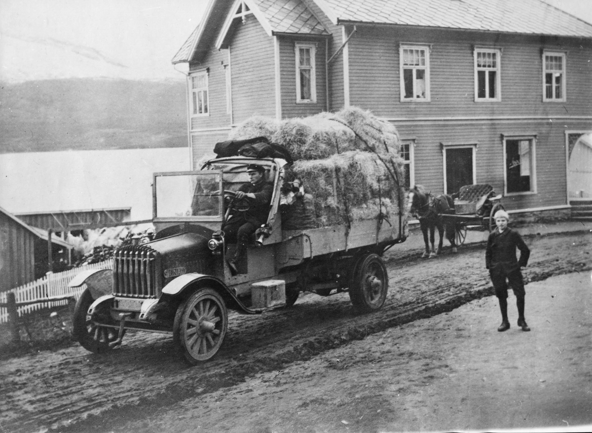 Lastebil foran Sjøveien Apotek. Bak bilen står en hestedrosje.