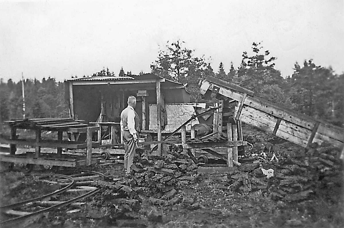 Anderstorps Stormosse ca 1942. Fridell vid en torvmaskin uppställd för hösten. Torvtäkt bedrevs här under andra världskriget. Täkten och de många diken som då grävdes på flera platser gjorde att delar av mossen torkade ut och blev trädklädd under andra halvan av 1900-talet.