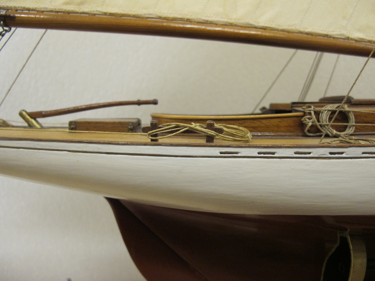Segelkutter, skärgårdskryssaren ALCA. Fullständigt inredd med kajuta och sittrum. Modell byggd i ett trä. Riggad. Mast i en längd med gaffelsegel, fock och klyvare. Flagga och igenkänningsstandert. Vitmålad, röd botten. Fernissat däck och inredning. Stativ fernissat och förgyllt.
Alca var  45, 2 fot lång och 8,9 fot bred
