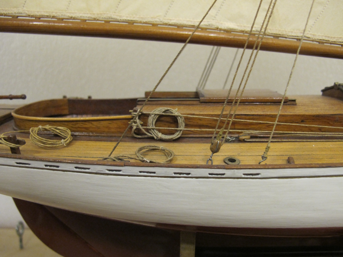 Segelkutter, skärgårdskryssaren ALCA. Fullständigt inredd med kajuta och sittrum. Modell byggd i ett trä. Riggad. Mast i en längd med gaffelsegel, fock och klyvare. Flagga och igenkänningsstandert. Vitmålad, röd botten. Fernissat däck och inredning. Stativ fernissat och förgyllt.
Alca var  45, 2 fot lång och 8,9 fot bred