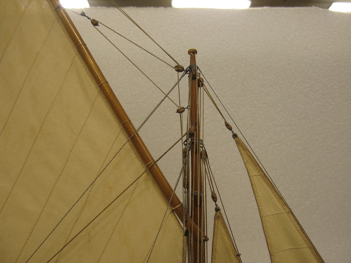 Segelkutter, skärgårdskryssaren ALCA. Fullständigt inredd med kajuta och sittrum. Modell byggd i ett trä. Riggad. Mast i en längd med gaffelsegel, fock och klyvare. Flagga och igenkänningsstandert. Vitmålad, röd botten. Fernissat däck och inredning. Stativ fernissat och förgyllt.
Alca var  45, 2 fot lång och 8,9 fot bred