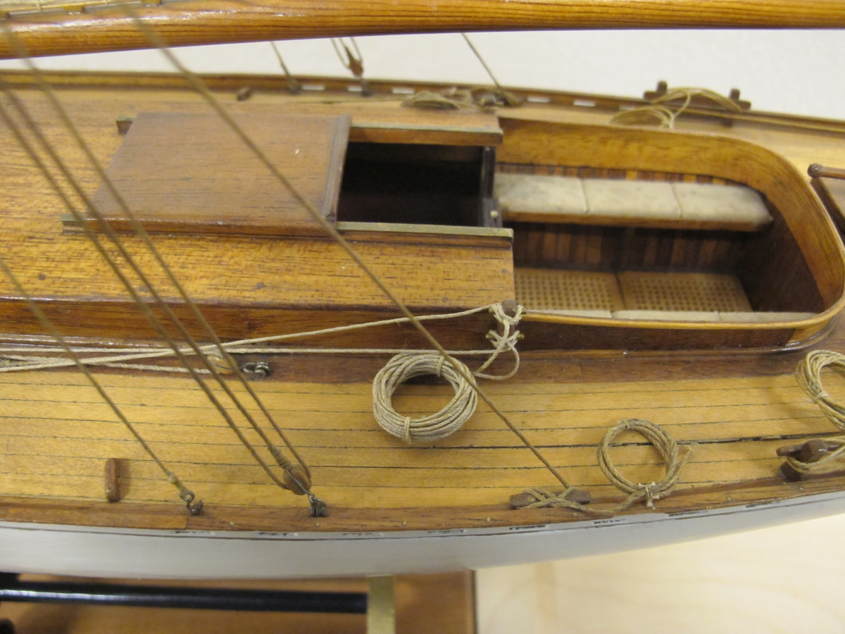 Segelkutter, skärgårdskryssaren ALCA. Fullständigt inredd med kajuta och sittrum. Modell byggd i ett trä. Riggad. Mast i en längd med gaffelsegel, fock och klyvare. Flagga och igenkänningsstandert. Vitmålad, röd botten. Fernissat däck och inredning. Stativ fernissat och förgyllt.
Alca var  45, 2 fot lång och 8,9 fot bred