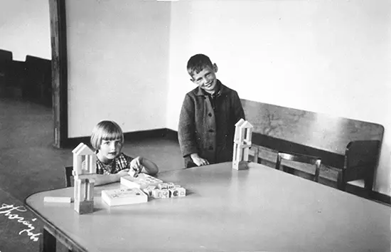 En pojke och en flicka som leker med klossar