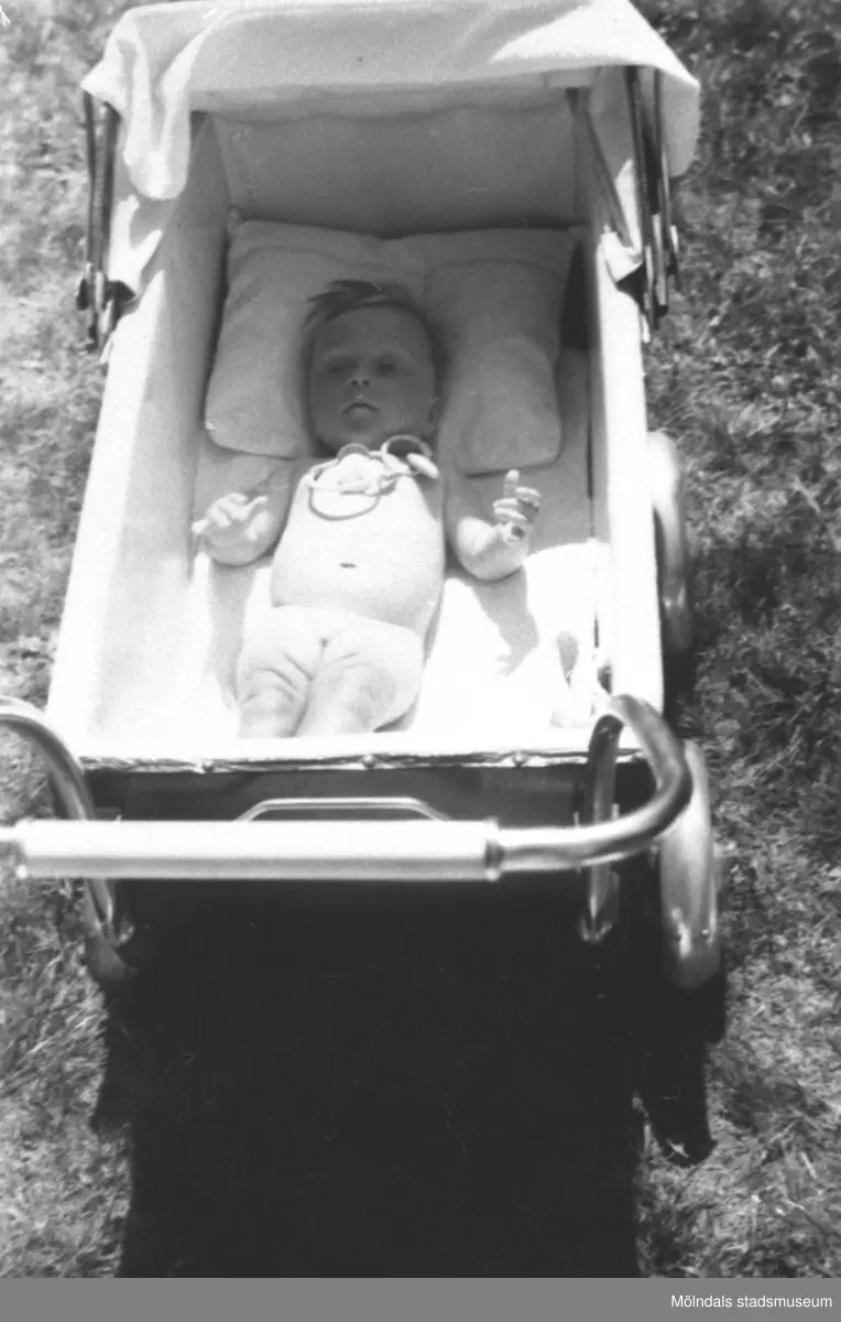 Karin Hansson (född: Pettersson) ligger i sin vagn, Torrekulla gård 1947.