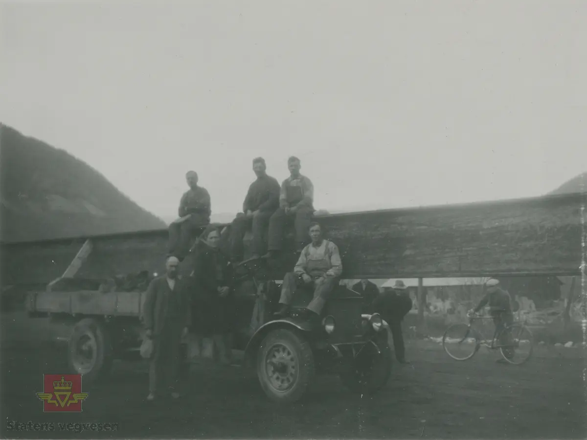 Album fra 1929-1943.  "Stålbjelketransport  forbi Vågåmo."  Knyttes til bildene NVM 00-F-32866, NVM 00-F-32867, NVM 00-F-32868.

23.06.2015: For sin tid var dette en stor lastebil.
24.06.2015: E-156 i fra Skjaakbilene er en Federal. 
25.06.2015: A/S Skjaakbilene ble etablert i 1919. De overtok da en Opel lastebil  i fra  Skjaak almenning. I bilsakskyndig A. Skaar sin regprotokoll ble bilen da tildelt regnr. E-156. Bilen ble solgt i 1921  og E-156 ble overført til en Federal med samme eier.  I reglistene for 1925 og 1930 er det fortsatt en Federal på dette  regnr.  Bilen på bildet er en tidlig 20 talls Federal. (Informant til kjøretøyet på bildet v/tidligere daglig leder John Hindklev ved Norsk Kjøretøyhistorisk Museum). 
25.06.2015: Årsmodell 1923 iflg. Norges Bilbok 1935, hvor den fortsatt står på samme eier. Merke og årstall stemmer med Tad Burness: American Truck Spotter's Guide 1920 - 1970.