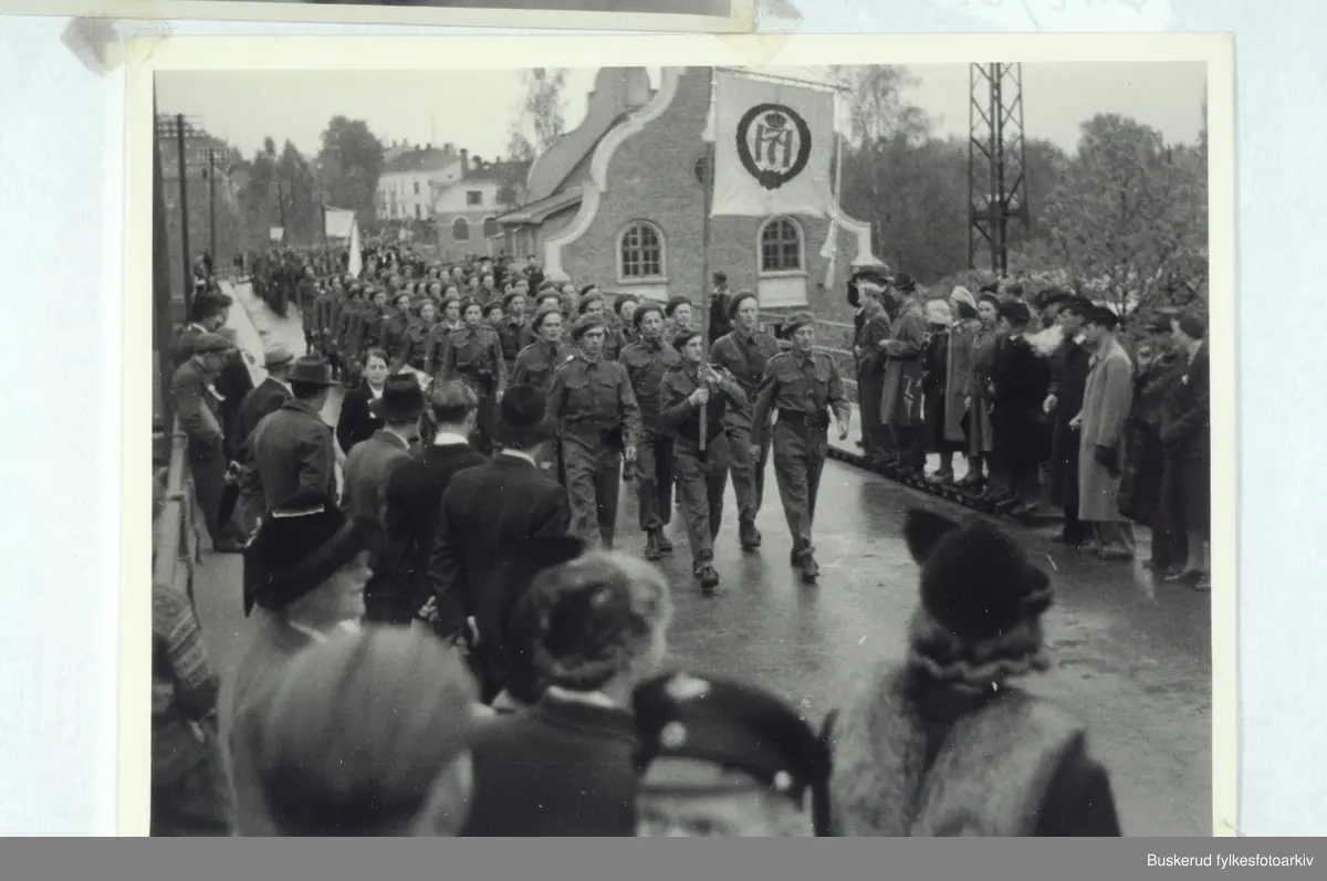 Hjemmestyrkene defilerer i Hønefoss 17. mai 1945. Ola Kvernstue med fanen, Georg Rua i spiss Karl Larsson, Kåre Hellum, Reidar Solbakken