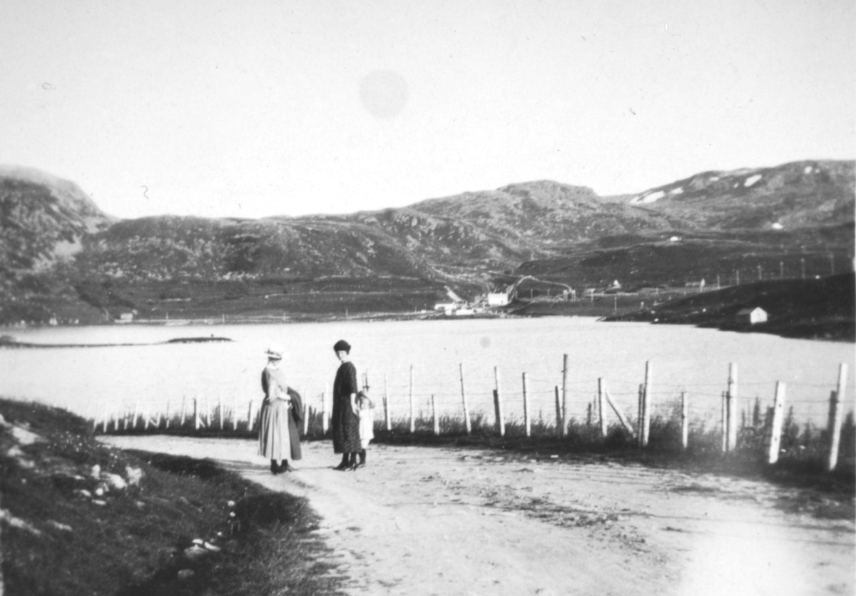 "Ved Hammerfest. Storvannet." To kvinner og et barn står på en grusvei i nærheten av Storvannet.