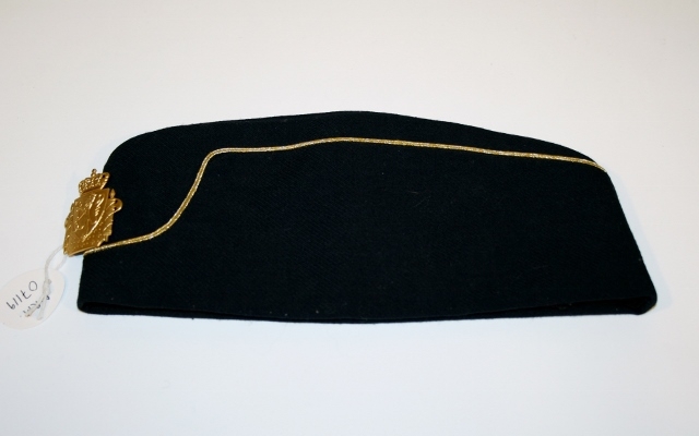 Uniform for politinspektør etter 1963-reglement med merking etter 1977-reglement. Helårsuniform M/1963 med skjorte, langbukse, belte, helårskappe og jakke. Skyggelue med gullbrodert bånd, loslue og båtlue M/1967. Kappen og jakken har skulderklaffer av flettede gullsnorer med to sølvstjerner og festeknapp i gullbroderi. Skjorten har en enklere skulderklaff med to gule render og to sølvstjerner. Det følger med et ekstra enkelt lærbelte og et ekstra sett skulderklaffer til skjorte. Plaggene har gullfargede løveknapper.