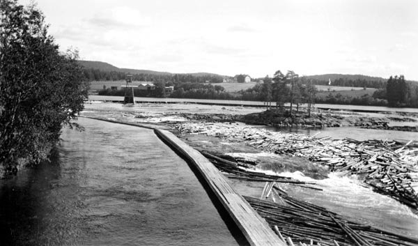 Funnefossen i Glomma i Nes kommune i Akershus, fotografert sommeren 1911.  Her faller elva i avsatser over en strekning på cirka 850 meter ti-elleve meter.  Midt i fossen ligger det en holme, som vi ser på fotografiet.  Særlig ved lavvann hadde fløtingstømmeret lett for å sette seg fast på steinskjær i fosseløpet, slik at det bygde seg opp hauger, noe vi også ser eksempel på i dette bildet.  Det var dessuten ei bakevje nedenfor fossen, hvor tømmeret også hadde lett for å hope seg opp.  Bakevja er ikke synlig på dette fotogtrafiet.  Derimot ser vi - til venstre i forgrunnen - en avskjermet kanal i den vestre delen av elveløpet.  Dette var sannsynligvis inntakskanalen for driftsvann til Funnefoss tresliperi, som ble etablert i midten av 1870-åra, og var i drift fram til 1966.  I venstre del av bildet, øverst i fossen, ser vi et tårn, som muligens var et bærende element for en strømkabel eller en taubane.