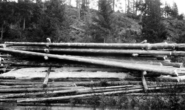 Såkalt strøvelte ved Høymodammen i Julussvassdraget i Elverum kommune i Hedmark, fotografert vinteren 1927.  Med de lange fløtingsdistansene man hadde i Glommavassdraget var det ønskelig at tømmeret fikk en forsiktigf tørk, før det ble slått på vassdragene.  En av måtene å løse dette på, var den vi ser på dette fotografiet.  Tømmerkjørerne la først et par stokker på elvebrinken, vinkelrett på vassdragets strømretning.  Oppå dette underlaget la de ei «flo» av tømmerstokker, tett inntil hverandre og parallelt med strømretningen.  Slik fortsatte de, med to «strøstokker» på tvers og floer på langs, inntil strøvelta var høy nok.  Denne tilleggingsmåten gjorde det enkelt å rulle stokkene uti vassdraget når vannstanden var høvelig for å starte fløtinga.  Denne strøvelta var ikke helt vellykket fordi den ble lagt for langt fram på elvebrinken, slik at noen av stokkene i frontpartiet raste ut lenge før det var aktuelt å foreta noe utislag.