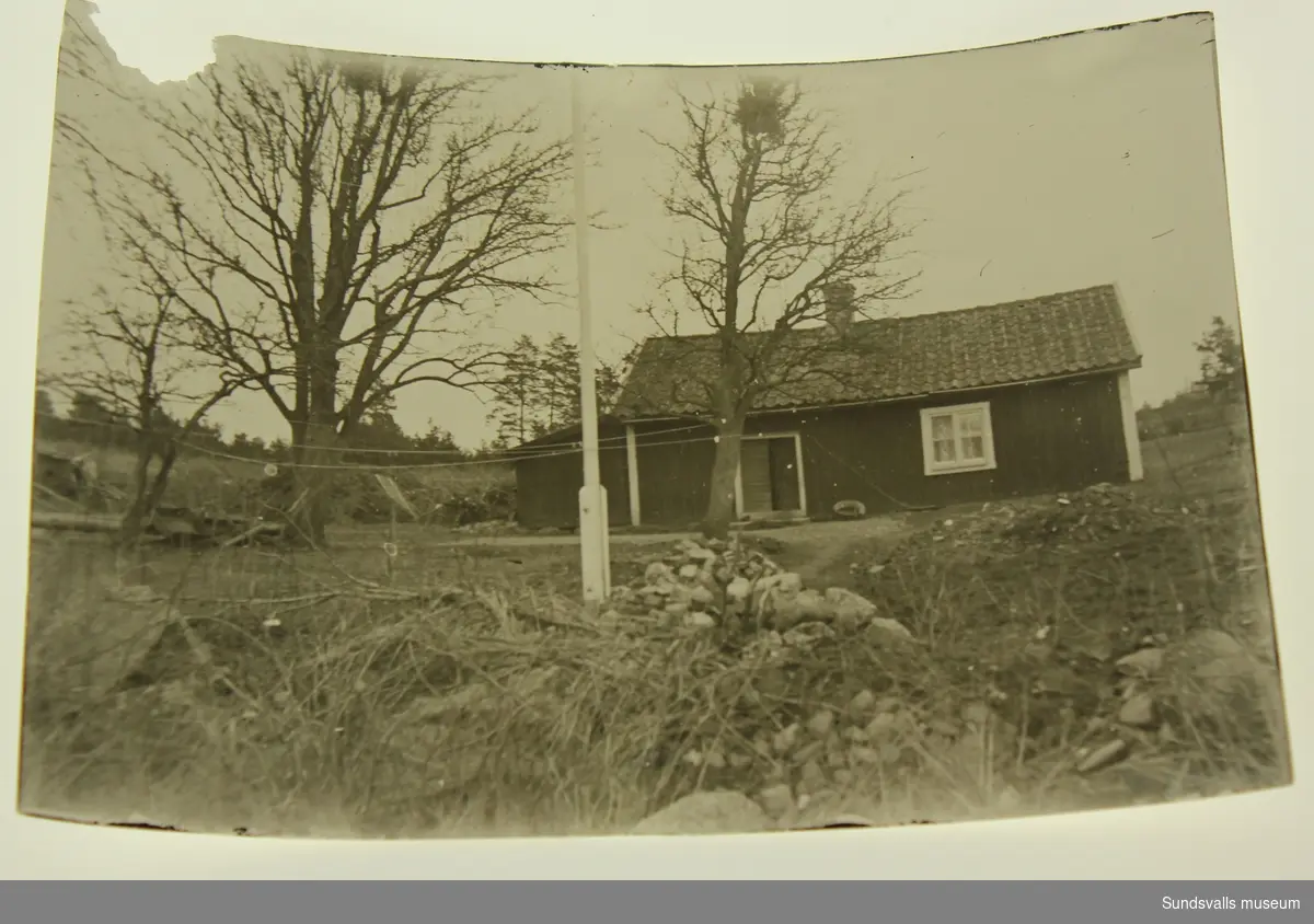 Ett mindre äldre hus med flaggstång framför.