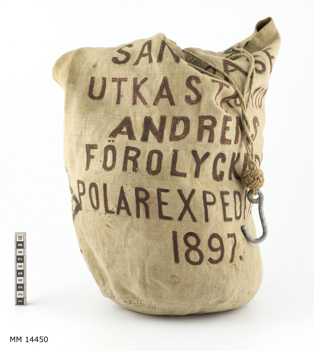 Handsydd, upptill försedd med fyra kauser. I vardera kausen är fastsatt en tregarnslina. Förenade med krok av galvaniserat järn.

Märkning: "Andrens polarexpedition 1897 samt "Sandpåse utkastad vid Andrens (sic!)
förolyckade polarexpedition 1897."