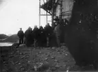 Turistgrupp vid ballonghuset på Danskön. Möjligen kapten Lund som hälsar på S A Andrée i bildens centrum. Intill den senare står N Strindberg.