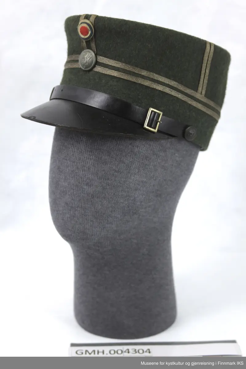 Uniformen besto opprinnelig av lue, jakke, bukse, belte og lærstøvler. Beltet og støvlene mangler. Uniformen består av mørkegrønn vadmel og har smale røde kanter ved yttersømmen til buksen, kragen og ved mansjettene. Luen / hatten har to parallelle gule striper rundt og på for- og baksiden. På fremsiden befinner seg en reim og et skjold som er svarte. På jakkens vestre armen er det festet en armbind med genferkors. Jakken lukkes med skjulte knapper i kunststoff . Den har to brystlommer og to sidelommer med klaff samt to metallhemper ved kragen. På innsiden til venstre befinner deg atter to lommer uten klaff. Jakken er foret med lyst, ubleket bomullsstoff. Den lange buksen er formet vid rundt lårbeinene, har to sidelommer og stropper nede. Den er en høy modell med knapper til seler og spensel i rygg. Buksen har en skult knepping i gylfen med metallknapper og en metallhempe øverst. Klærne er stemplet på innsidene.