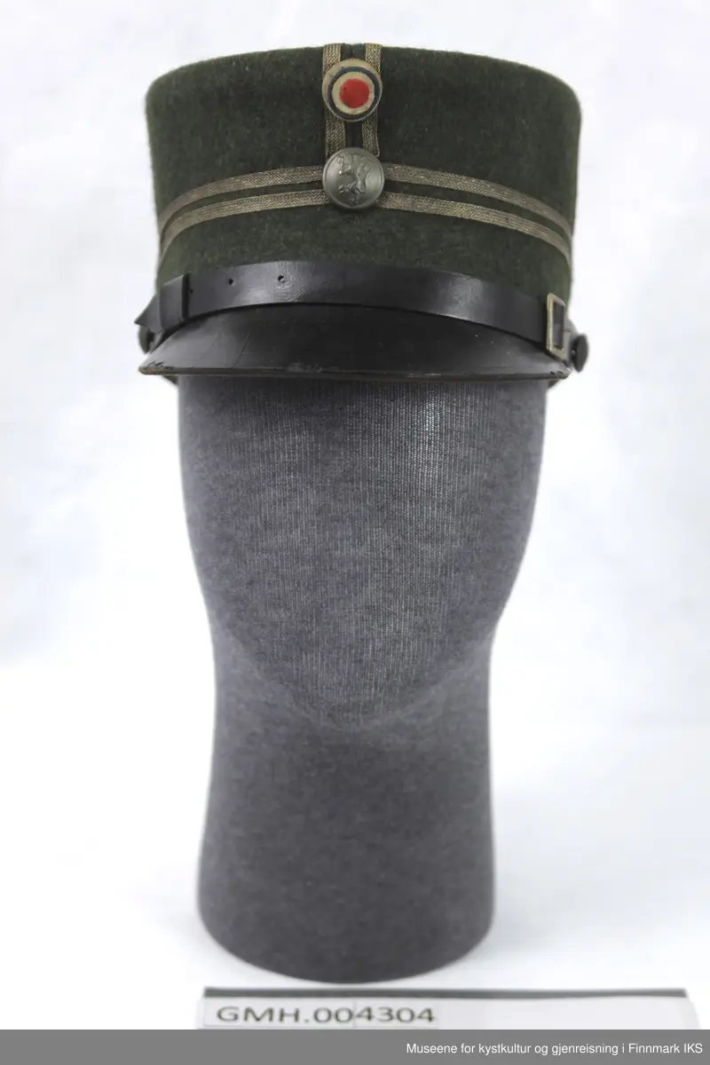 Uniformen besto opprinnelig av lue, jakke, bukse, belte og lærstøvler. Beltet og støvlene mangler. Uniformen består av mørkegrønn vadmel og har smale røde kanter ved yttersømmen til buksen, kragen og ved mansjettene. Luen / hatten har to parallelle gule striper rundt og på for- og baksiden. På fremsiden befinner seg en reim og et skjold som er svarte. På jakkens vestre armen er det festet en armbind med genferkors. Jakken lukkes med skjulte knapper i kunststoff . Den har to brystlommer og to sidelommer med klaff samt to metallhemper ved kragen. På innsiden til venstre befinner deg atter to lommer uten klaff. Jakken er foret med lyst, ubleket bomullsstoff. Den lange buksen er formet vid rundt lårbeinene, har to sidelommer og stropper nede. Den er en høy modell med knapper til seler og spensel i rygg. Buksen har en skult knepping i gylfen med metallknapper og en metallhempe øverst. Klærne er stemplet på innsidene.