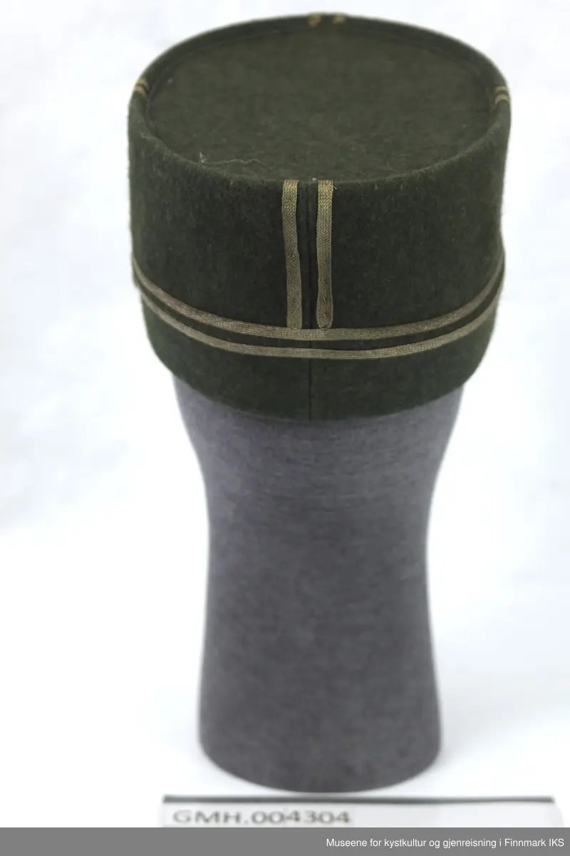 Uniformen besto opprinnelig av lue, jakke, bukse, belte og lærstøvler. Beltet og støvlene mangler. Uniformen består av mørkegrønn vadmel og har smale røde kanter ved yttersømmen til buksen, kragen og ved mansjettene. Luen / hatten har to parallelle gule striper rundt og på for- og baksiden. På fremsiden befinner seg en reim og et skjold som er svarte. På jakkens vestre armen er det festet en armbind med genferkors. Jakken lukkes med skjulte knapper i kunststoff . Den har to brystlommer og to sidelommer med klaff samt to metallhemper ved kragen. På innsiden til venstre befinner deg atter to lommer uten klaff. Jakken er foret med lyst, ubleket bomullsstoff. Den lange buksen er formet vid rundt lårbeinene, har to sidelommer og stropper nede. Den er en høy modell med knapper til seler og spensel i rygg. Buksen har en skult knepping i gylfen med metallknapper og en metallhempe øverst. Klærne er stemplet på innsidene.