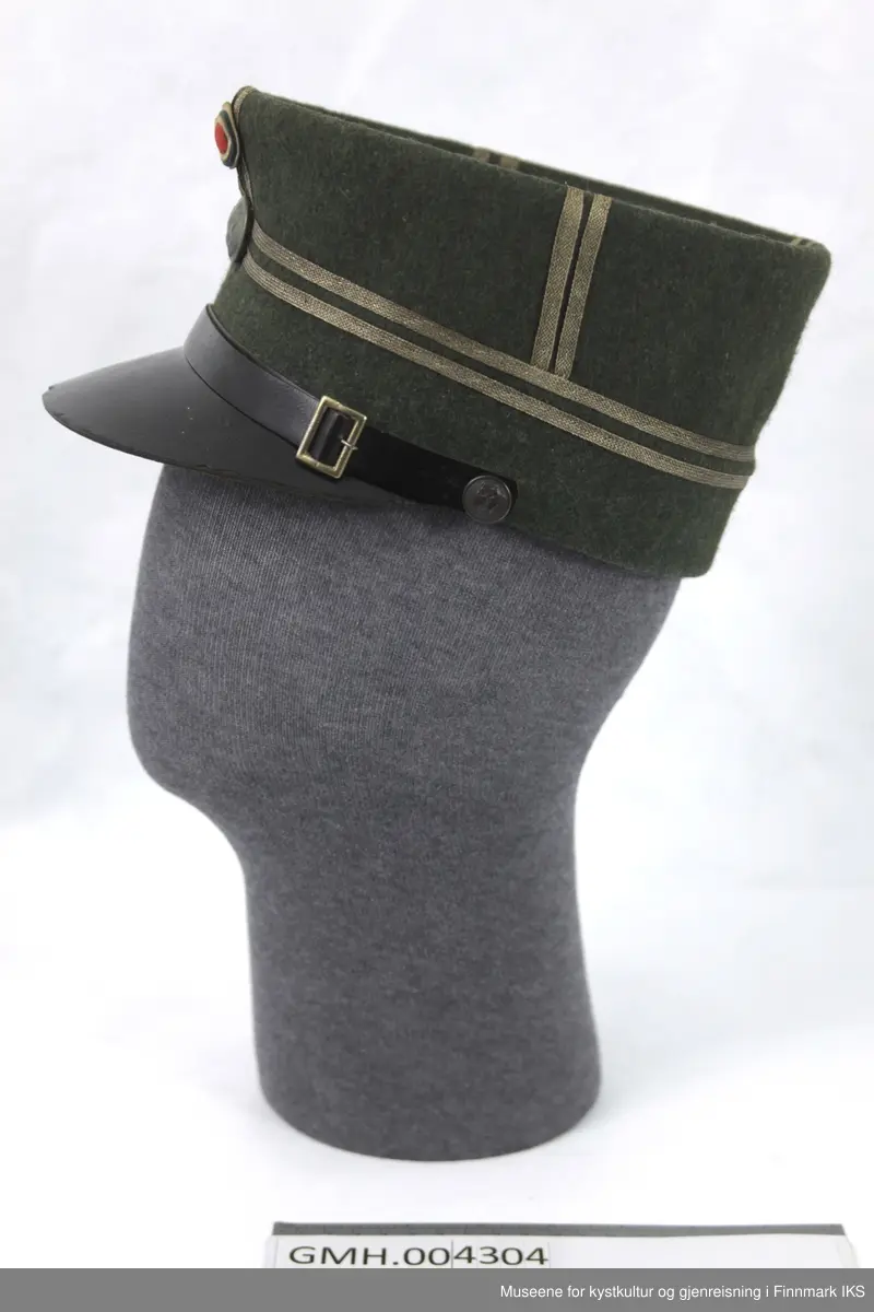 Uniformen besto opprinnelig av lue, jakke, bukse, belte og lærstøvler. Beltet og støvlene mangler. Uniformen består av mørkegrønn vadmel og har smale røde kanter ved yttersømmen til buksen, kragen og ved mansjettene. Luen / hatten har to parallelle gule striper rundt og på for- og baksiden. På fremsiden befinner seg en reim og et skjold som er svarte. På jakkens vestre armen er det festet en armbind med genferkors. Jakken lukkes med skjulte knapper i kunststoff . Den har to brystlommer og to sidelommer med klaff samt to metallhemper ved kragen. På innsiden til venstre befinner deg atter to lommer uten klaff. Jakken er foret med lyst, ubleket bomullsstoff. Den lange buksen er formet vid rundt lårbeinene, har to sidelommer og stropper nede. Den er en høy modell med knapper til seler og spensel i rygg. Buksen har en skult knepping i gylfen med metallknapper og en metallhempe øverst. Klærne er stemplet på innsidene.