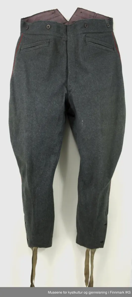 Uniformen besto opprinnelig av lue, jakke, bukse, belte og lærstøvler. Beltet og støvlene mangler. Uniformen består av mørkegrønn vadmel og har smale røde kanter ved yttersømmen til buksen, kragen og ved mansjettene. Luen / hatten har to parallelle gule striper rundt og på for- og baksiden. På fremsiden befinner seg en reim og et skjold som er svarte. På jakkens vestre armen er det festet en armbind med genferkors. Jakken lukkes med skjulte knapper i kunststoff . Den har to brystlommer og to sidelommer med klaff samt to metallhemper ved kragen. På innsiden til venstre befinner deg atter to lommer uten klaff. Jakken er foret med lyst, ubleket bomullsstoff. Den lange buksen er formet vid rundt lårbeinene, har to sidelommer og stropper nede. Den er en høy modell med knapper til seler og spensel i rygg. Buksen har en skult knepping i gylfen med metallknapper og en metallhempe øverst. Klærne er stemplet på innsidene.