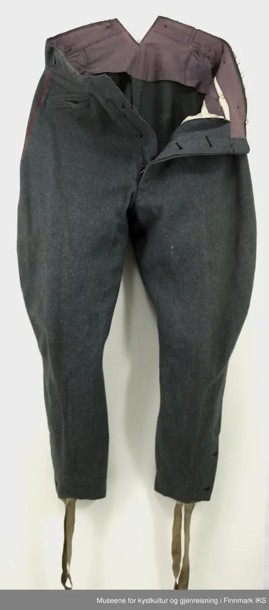 Uniformen besto opprinnelig av lue, jakke, bukse, belte og lærstøvler. Beltet og støvlene mangler. Uniformen består av mørkegrønn vadmel og har smale røde kanter ved yttersømmen til buksen, kragen og ved mansjettene. Luen / hatten har to parallelle gule striper rundt og på for- og baksiden. På fremsiden befinner seg en reim og et skjold som er svarte. På jakkens vestre armen er det festet en armbind med genferkors. Jakken lukkes med skjulte knapper i kunststoff . Den har to brystlommer og to sidelommer med klaff samt to metallhemper ved kragen. På innsiden til venstre befinner deg atter to lommer uten klaff. Jakken er foret med lyst, ubleket bomullsstoff. Den lange buksen er formet vid rundt lårbeinene, har to sidelommer og stropper nede. Den er en høy modell med knapper til seler og spensel i rygg. Buksen har en skult knepping i gylfen med metallknapper og en metallhempe øverst. Klærne er stemplet på innsidene.