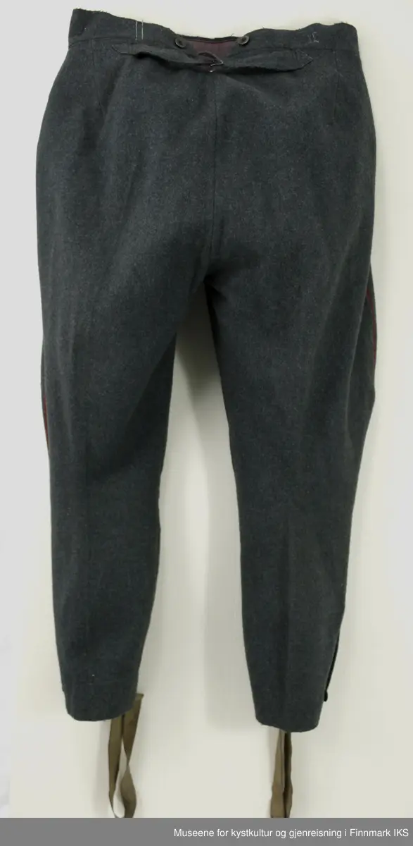 Uniformen besto opprinnelig av lue, jakke, bukse, belte og lærstøvler. Beltet og støvlene mangler. Uniformen består av mørkegrønn vadmel og har smale røde kanter ved yttersømmen til buksen, kragen og ved mansjettene. Luen / hatten har to parallelle gule striper rundt og på for- og baksiden. På fremsiden befinner seg en reim og et skjold som er svarte. På jakkens vestre armen er det festet en armbind med genferkors. Jakken lukkes med skjulte knapper i kunststoff . Den har to brystlommer og to sidelommer med klaff samt to metallhemper ved kragen. På innsiden til venstre befinner deg atter to lommer uten klaff. Jakken er foret med lyst, ubleket bomullsstoff. Den lange buksen er formet vid rundt lårbeinene, har to sidelommer og stropper nede. Den er en høy modell med knapper til seler og spensel i rygg. Buksen har en skult knepping i gylfen med metallknapper og en metallhempe øverst. Klærne er stemplet på innsidene.