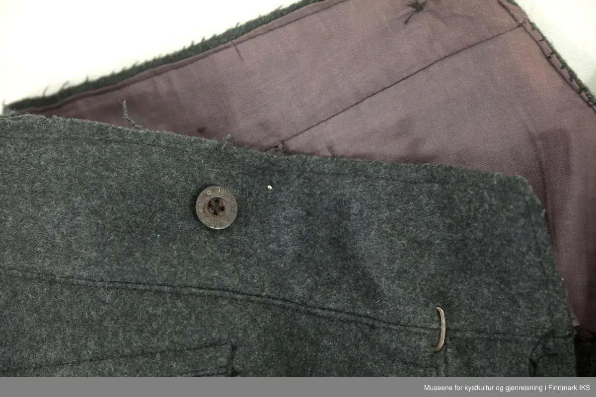 Uniformen besto opprinnelig av lue, jakke, bukse, belte og lærstøvler. Beltet og støvlene mangler. Uniformen består av mørkegrønn vadmel og har smale røde kanter ved yttersømmen til buksen, kragen og ved mansjettene. Luen / hatten har to parallelle gule striper rundt og på for- og baksiden. På fremsiden befinner seg en reim og et skjold som er svarte. På jakkens vestre armen er det festet en armbind med genferkors. Jakken lukkes med skjulte knapper i kunststoff . Den har to brystlommer og to sidelommer med klaff samt to metallhemper ved kragen. På innsiden til venstre befinner deg atter to lommer uten klaff. Jakken er foret med lyst, ubleket bomullsstoff. Den lange buksen er formet vid rundt lårbeinene, har to sidelommer og stropper nede. Den er en høy modell med knapper til seler og spensel i rygg. Buksen har en skult knepping i gylfen med metallknapper og en metallhempe øverst. Klærne er stemplet på innsidene.