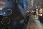 Marinmuseums ubåtshall med ubåten NEPTUN. Många människor på besök och som väntar på att få gå in i ubåten.