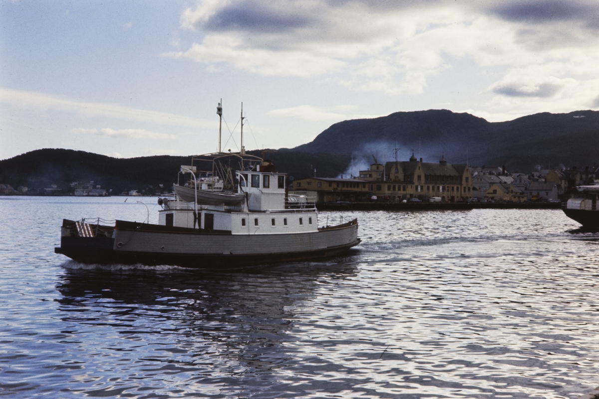 Ferge på vei ut fra Harstad, med dampskipskaia i bakgrunnen.