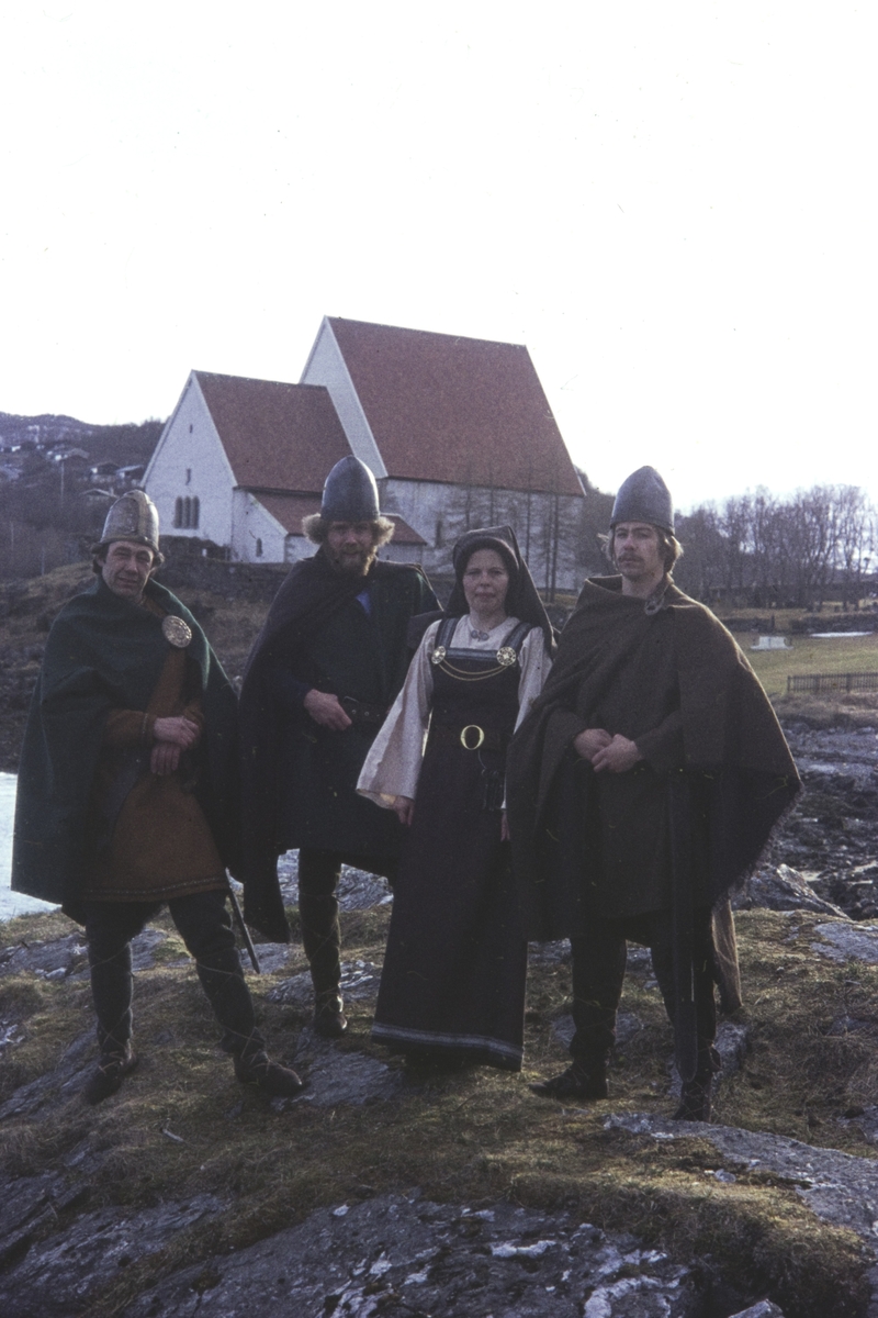 Fire skuespillere i kostymer fra sagaspill, fotografert foran Trondenes kirke.