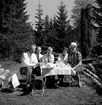 Med campingbord, stolar och Primuskök har man åkt ut i naturen för att dricka kaffe. Det är Arvid Ottosson, Evert, Tom och Elin Andersson och Karin Ottosson.