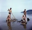 Fyra pojkar paddlar en flotte vid Vätterstranden vid Oset i Huskvarna. Stående från vänster: Arne Käll (1) och Kalle Sandén (2). Sittande: Kenneth Sandén (1) och Tom Andersson (2).